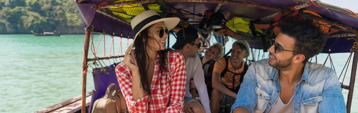 younger travelers in a boat in a tropical location