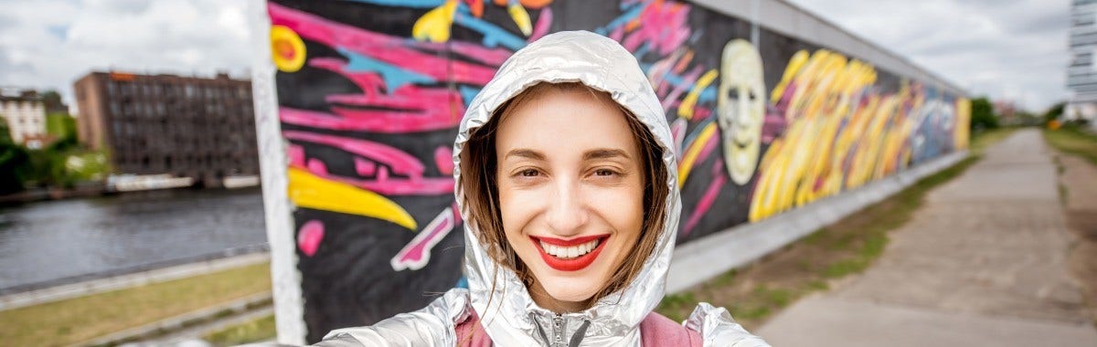 woman on a trip to Singapore with a pagoda style building in the foreground and cityscape in the background