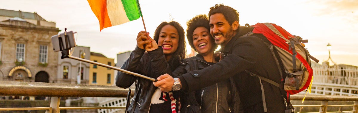 group of friends taking selfie with ireland flag