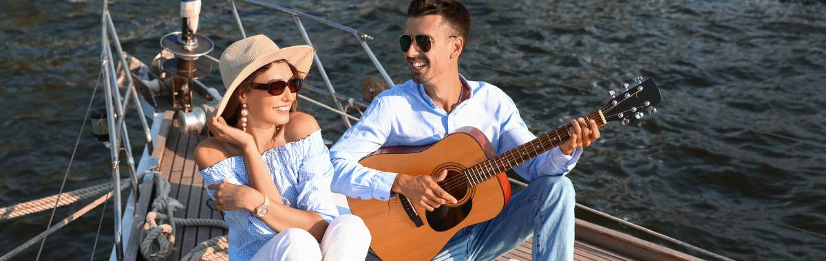 couple on sailboat playing guitar