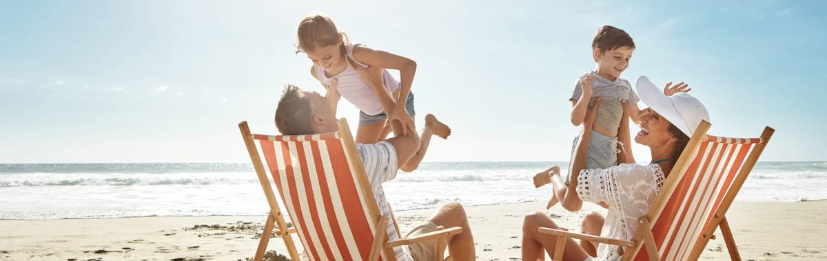 parents on beach playing with their children