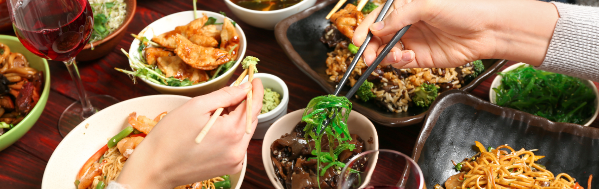 family sharing food with chopsticks