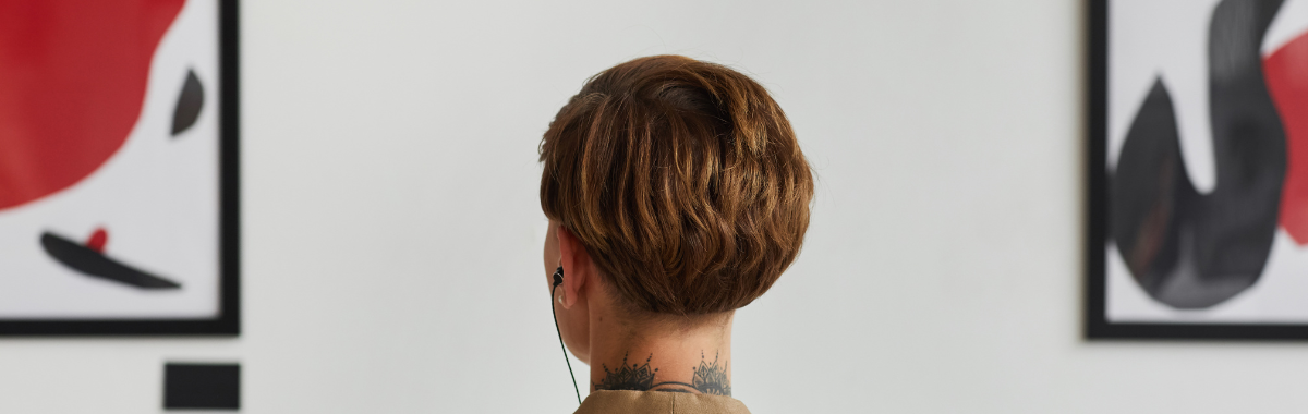 woman looking at art with an ear piece in