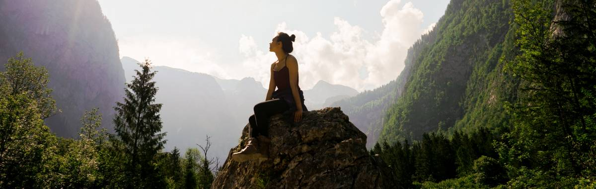 woman sitting on a rock in a valley