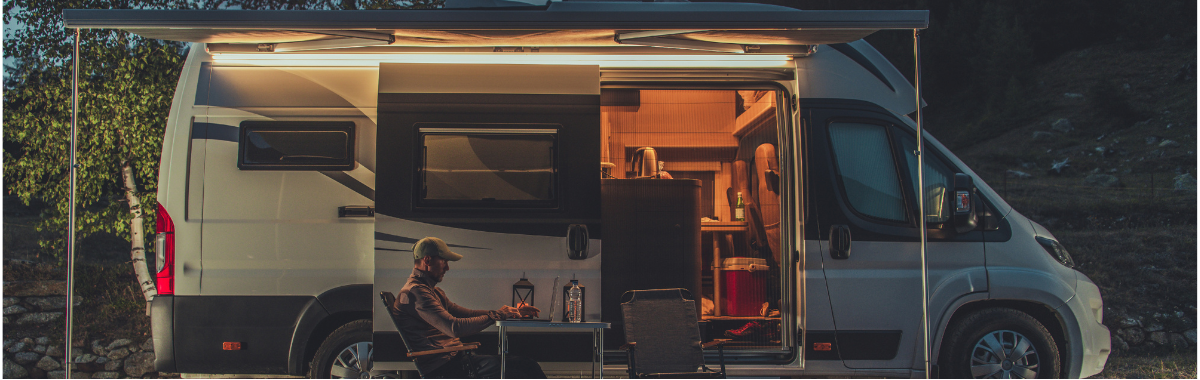 man camping right outside his RV Van
