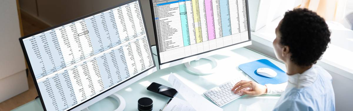 woman looking at spreadsheets on computer