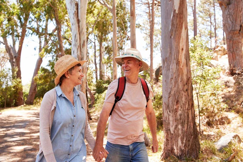 senior couple walking in woods