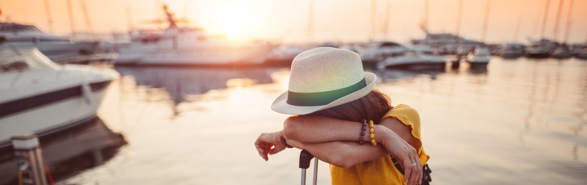 girl standing on dock with her luggage 