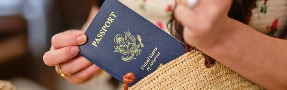 woman pulling out a passport from her beach bag