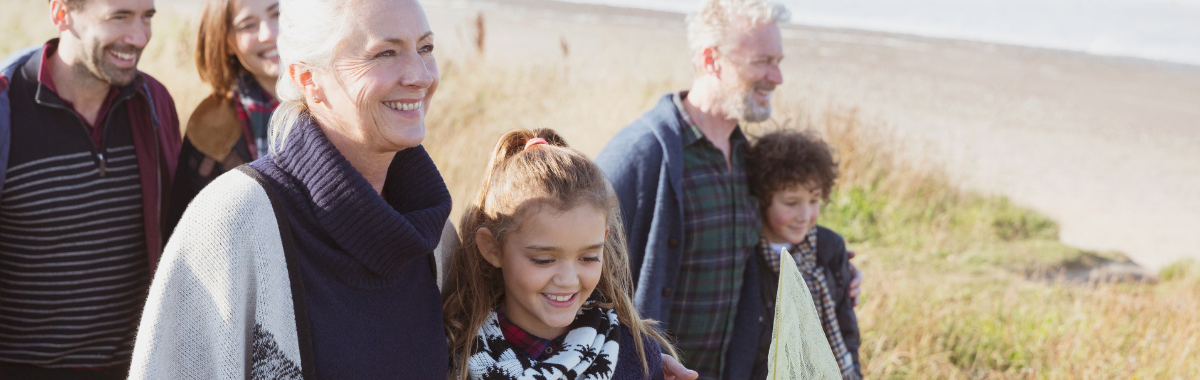 multigenerational family walking together on a beach