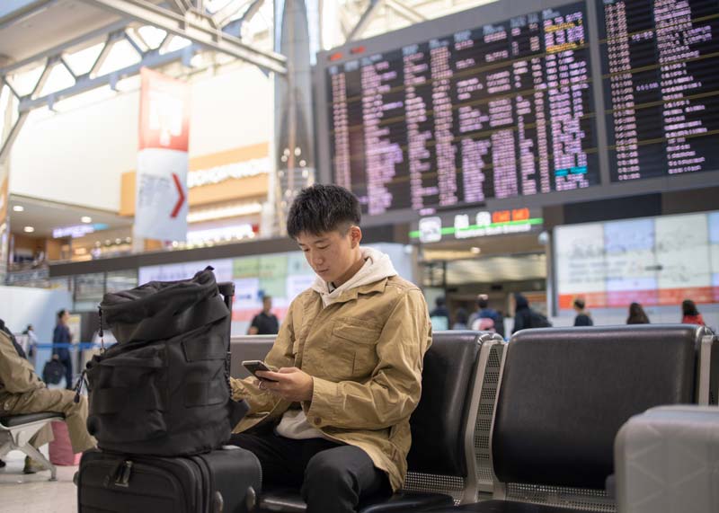 teenage solo traveler at the airport with luggage