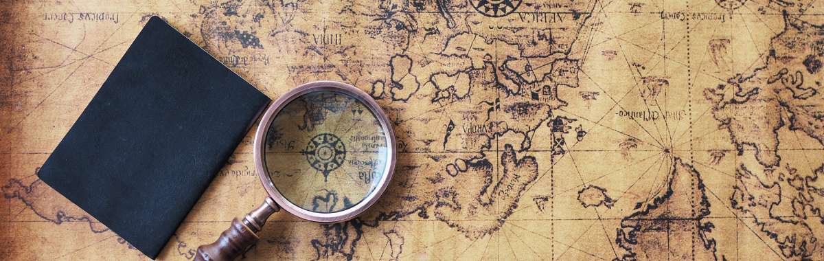 magnifying glass over top a map with a passport next to it