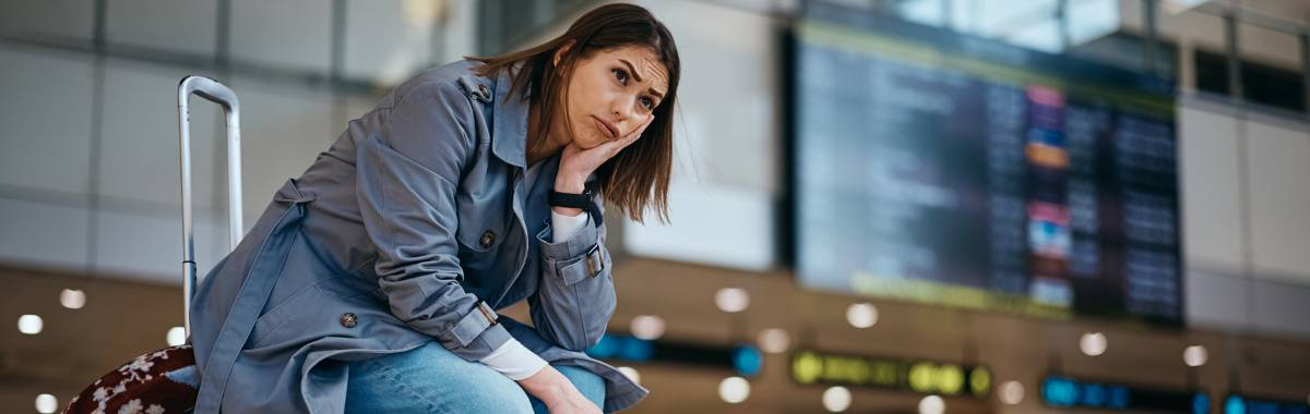 woman sitting on her luggage in an aiport