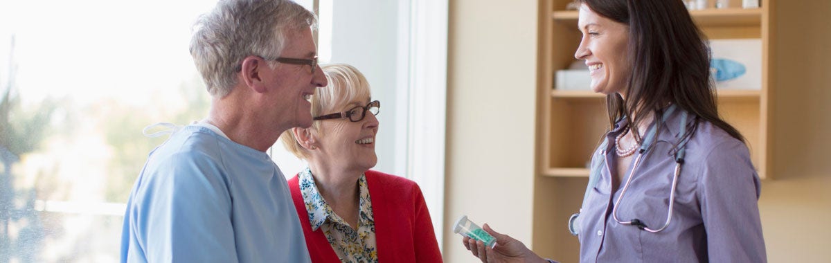 two seniors consulting with a doctor about medication