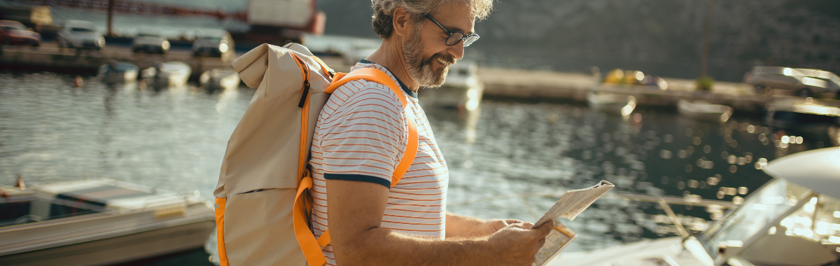 older man reading a map while on a boat dock