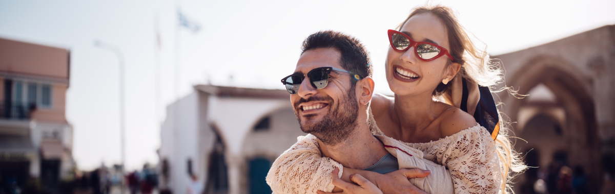 couple laughing and walking around a boardwalk