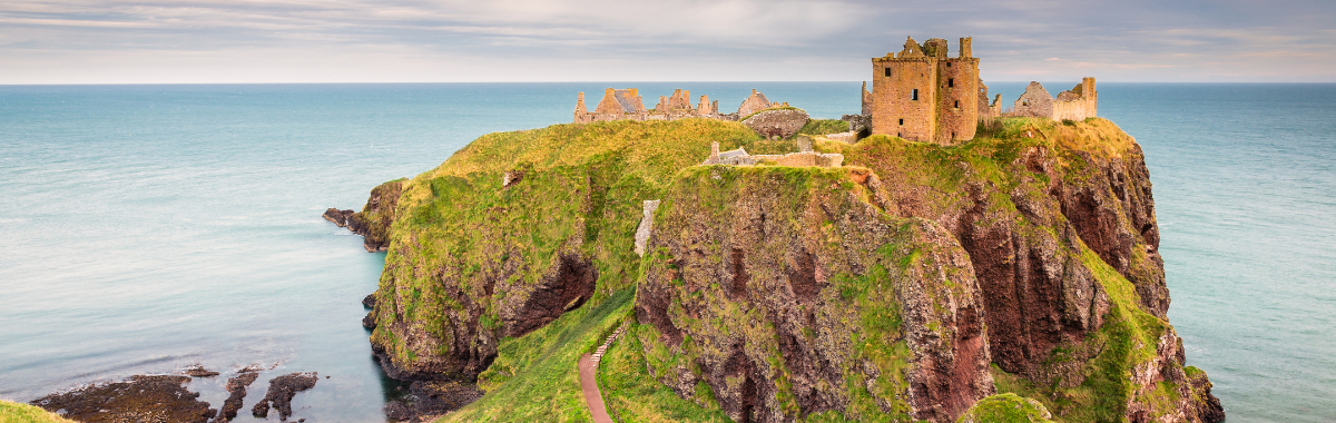 ruins of a scotish castle on a mountain top by the sea