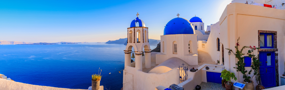 classic greek white and blue buildings with the ocean in the background