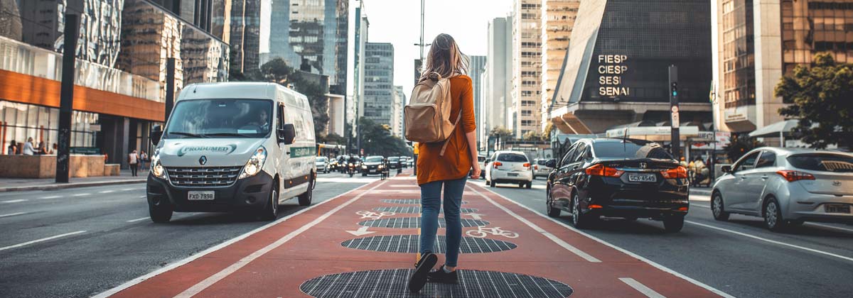 woman standing in the middle of a city street looking up
