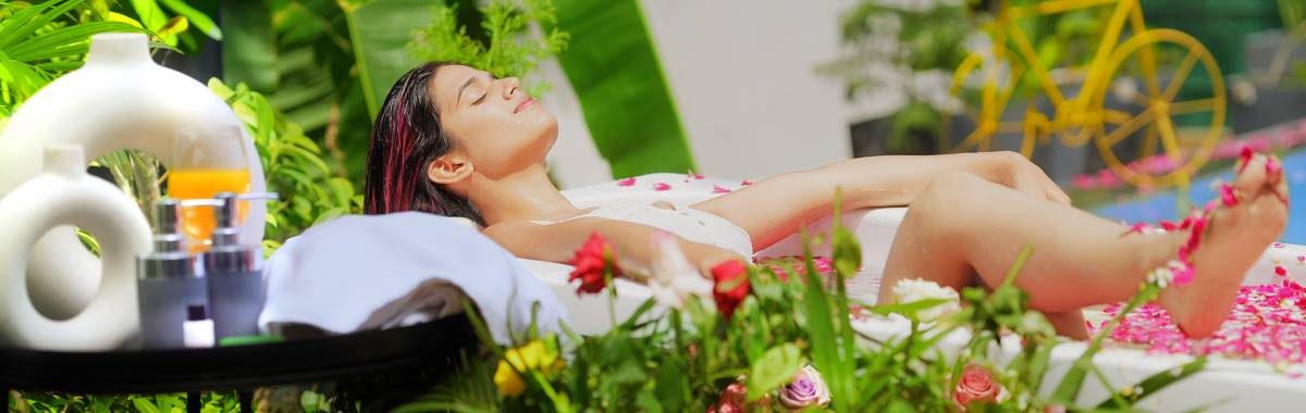 woman relaxing in a bath full of flowers
