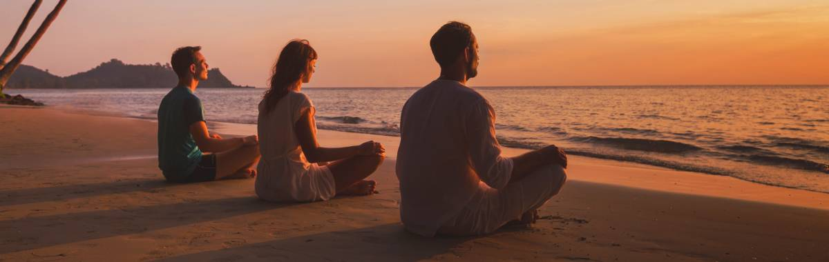 people meditating on a beach
