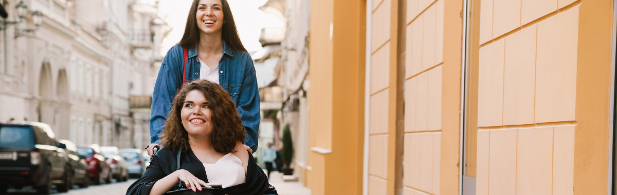 woman pushing another woman in a wheelchair
