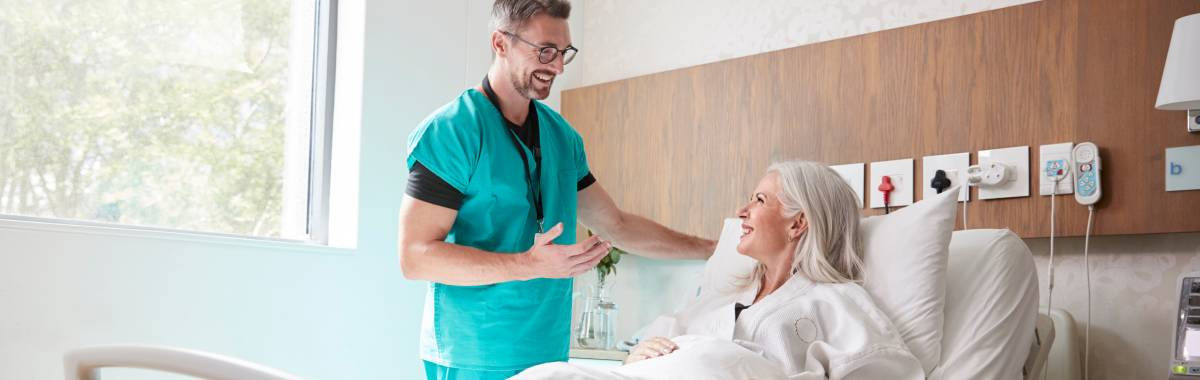 nurse helping woman in hospital bed
