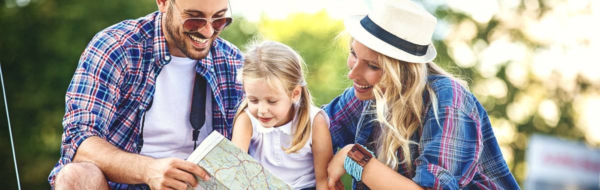 family with a kid looking at a map smiling