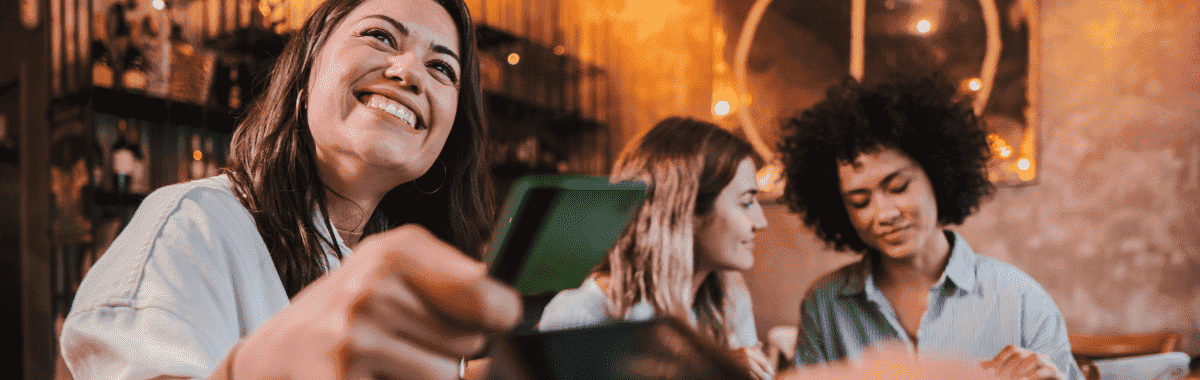 group of friends having dinner with a girl paying with her credit card