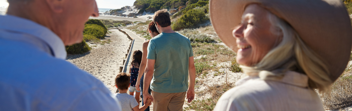 grandparents smiling looking at family on beach