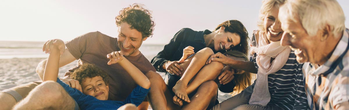 family playing around on the beach