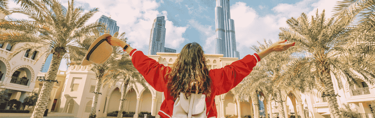 woman with arms wide open to a UAE skyscraper