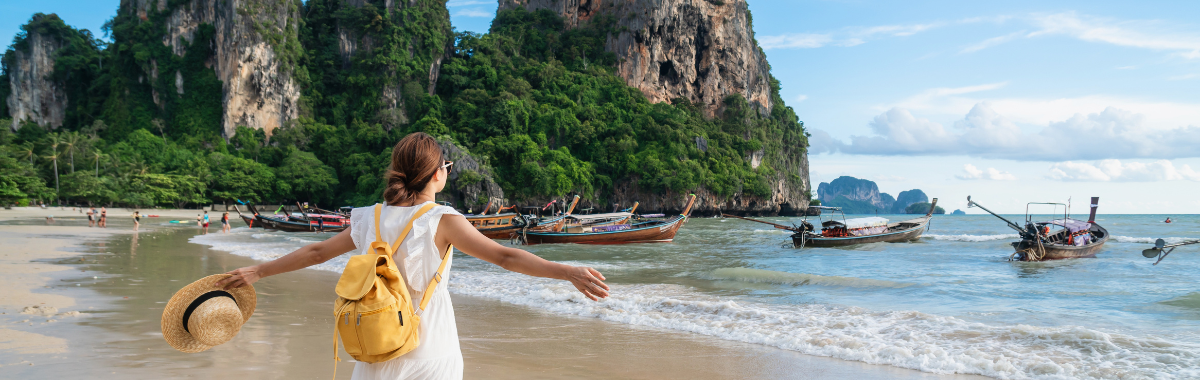 woman on a tropical beach with her arms wide open