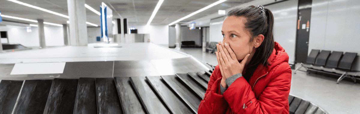 woman on a kayak with her arms out stretched over a emerald green lake
