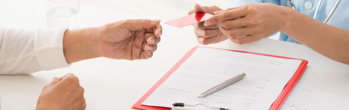 doctor giving patient medical ID and form