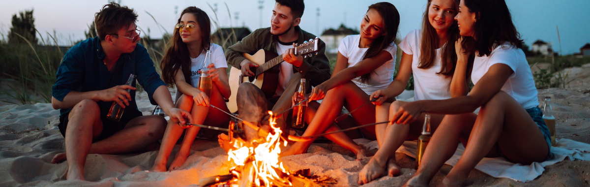 friends sat around a fire on the beach