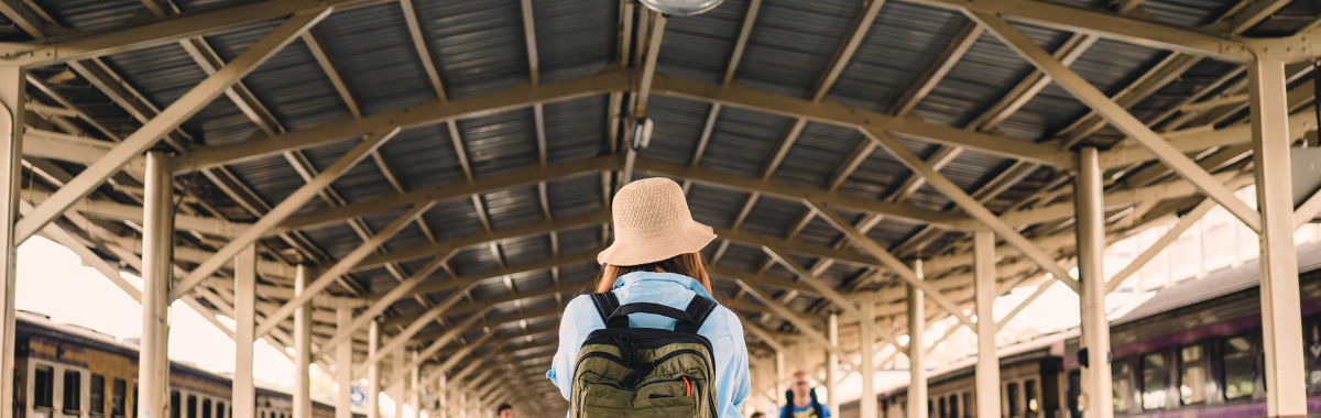 woman walking through transit hub with a backpack