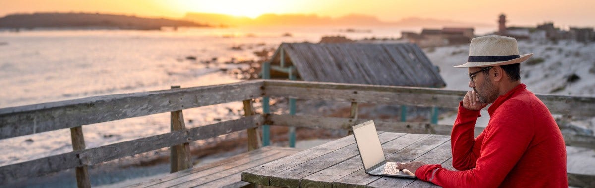 guy in a red sweater working at a bench on a beach