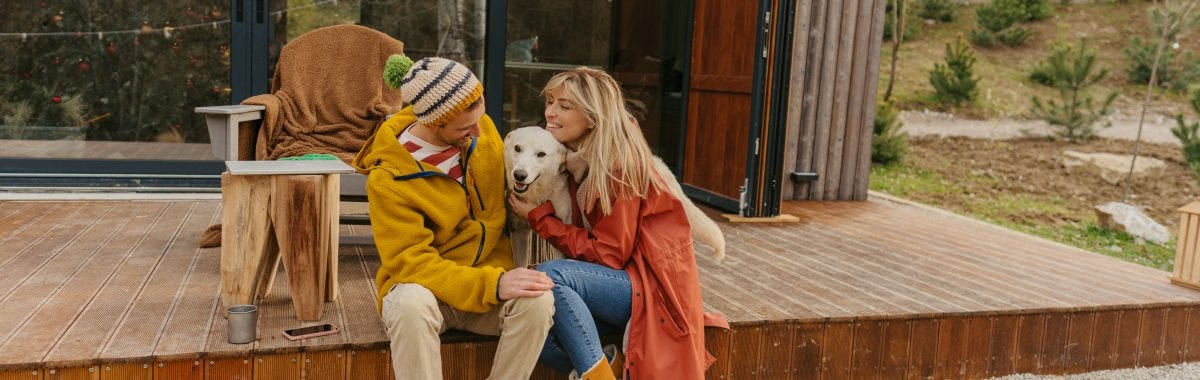 couple sitting on a porch with their dog between them