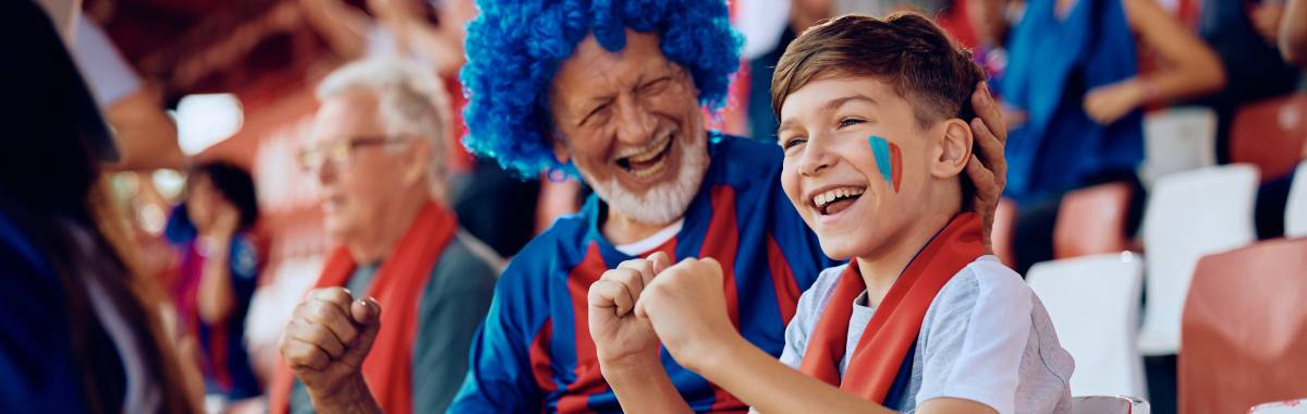 grandpa and grandkid cheering on their sports team at a game