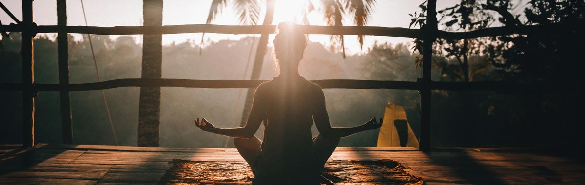 woman meditating and relaxing in a treehouse