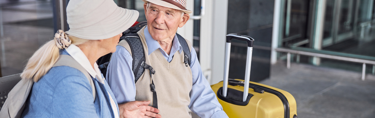 senior travelers sitting outside airport