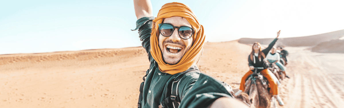 selfie of a guy riding camelback in the desert 