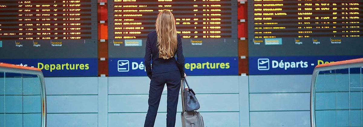 woman infront of airport departure screen