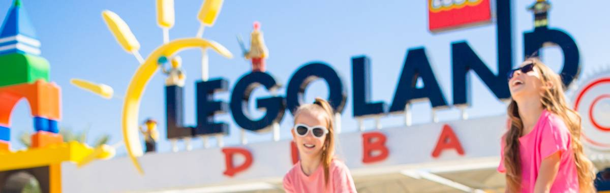 two kids with the legoland dubai sign behind them