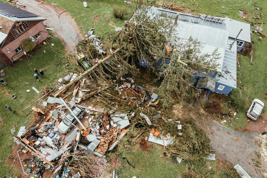home damaged by a storm with tree fallen on it