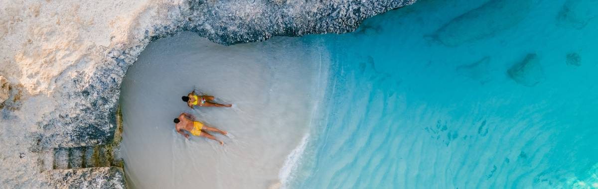 couple relaxing on a beach next to water