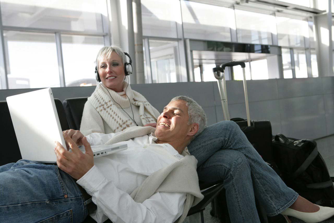 two people on a laptop at an airport