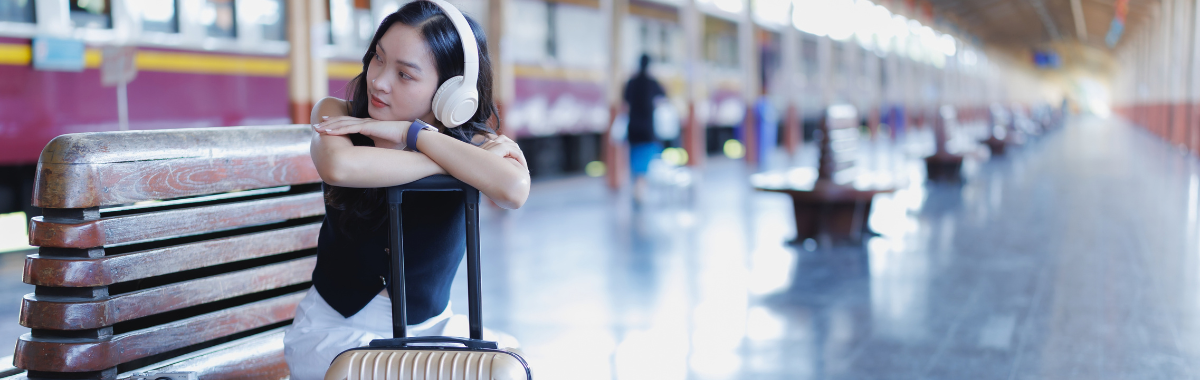 woman sitting on a bench with her luggage and camera