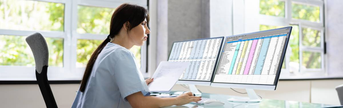 woman looking over documents and computer
